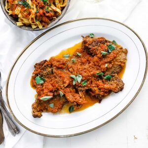 cooked steak with tomatoes sauce and oregano on a platter
