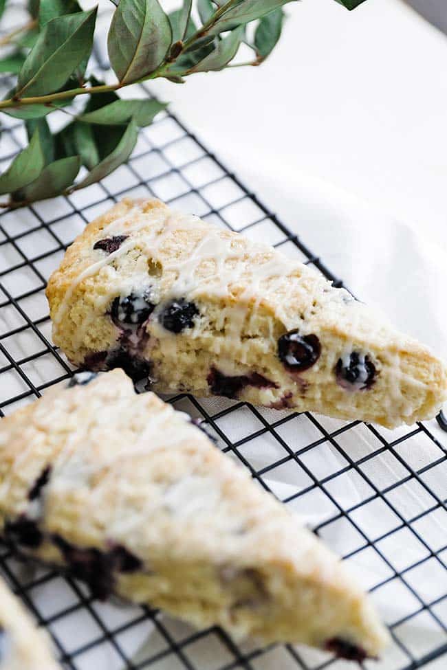 blueberry scones with a glaze on a resting rack