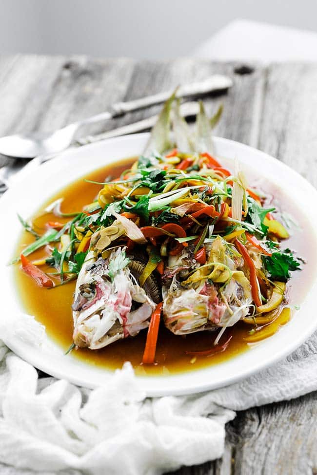 whole cooked fish with vegetables on a platter