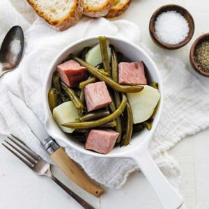 bowl with ham, green beans and potatoes next to sliced bread