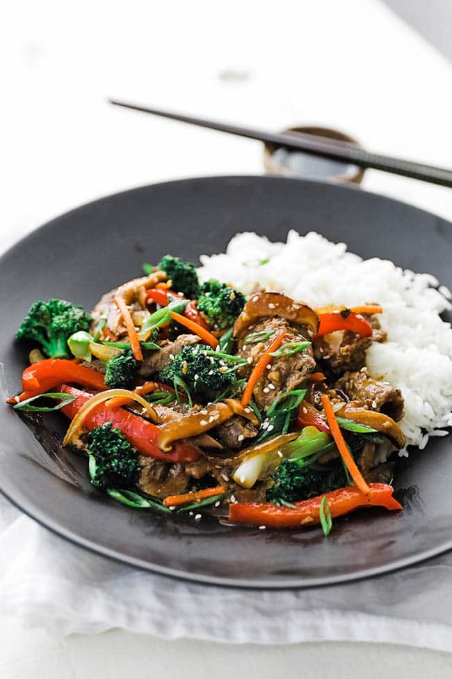 black plate of beef, vegetables and white rice