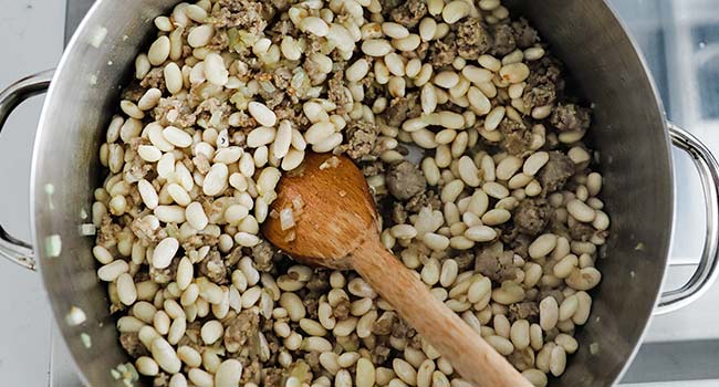 cooking beans and sausage in a pot