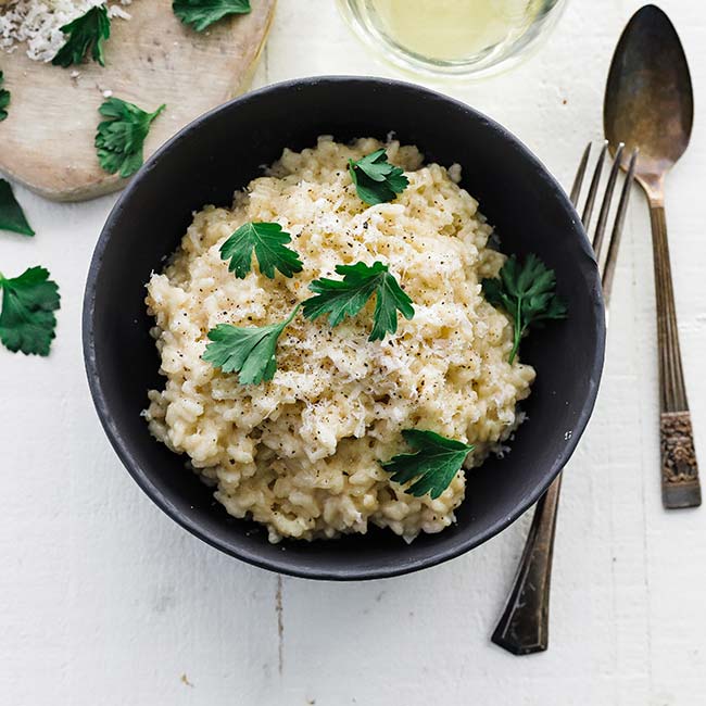 bowl of creamy risotto with parsley leaves for garnish
