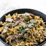 beef stroganoff with parsley and egg noodles on a plate