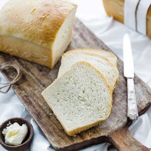 bread slices on a cutting board with a loaf of bread