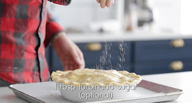 adding sugar to the top of an apple pie