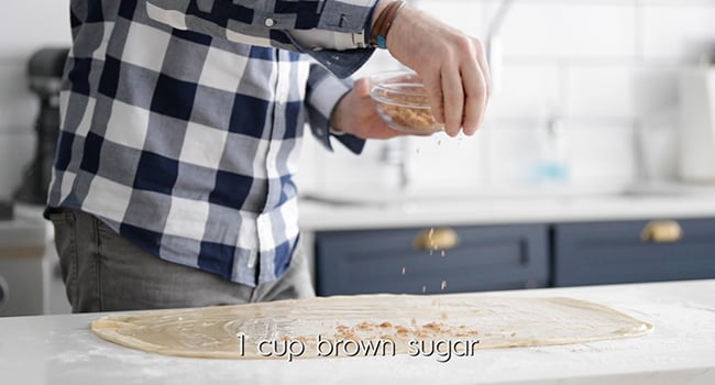 adding cinnamon, sugar, and, butter to dough