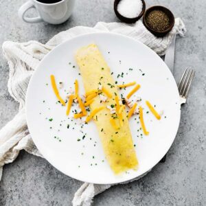 french omelette on a plate with cheese and parsley