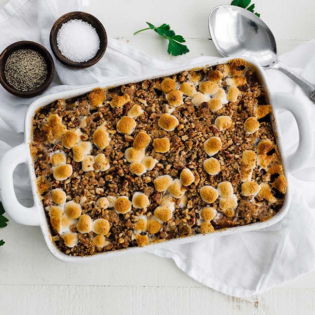 casserole dish with toasted marshmallows and pecans with sweet potato filling