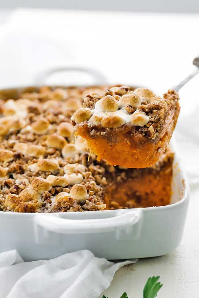 taking a scoop out of a sweet potato casserole 