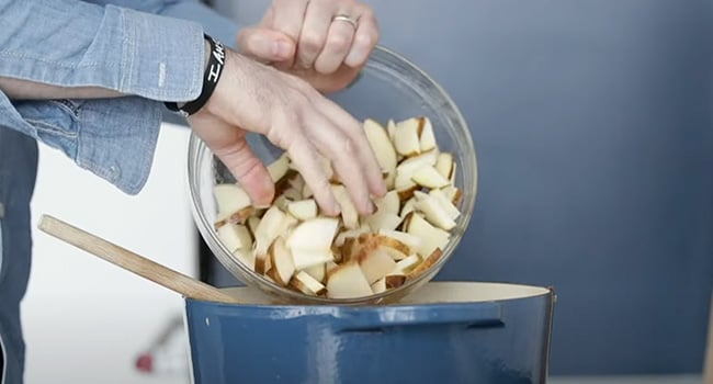 adding potatoes to a pot