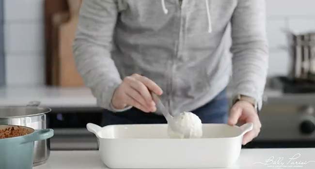 adding bechamel to a casserole dish