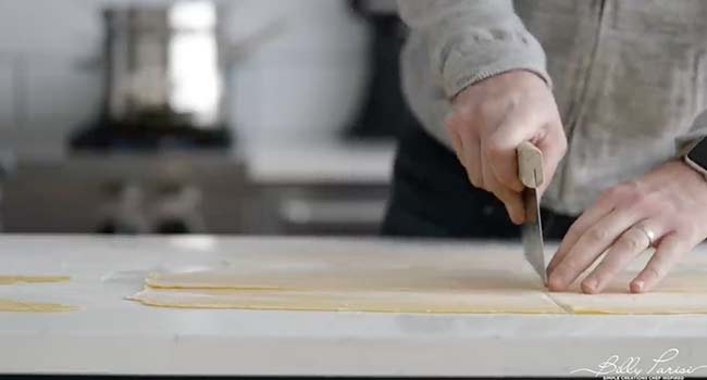 cutting rolled out pasta dough