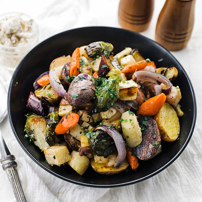 roasted vegetables in a bowl with parsley garnish