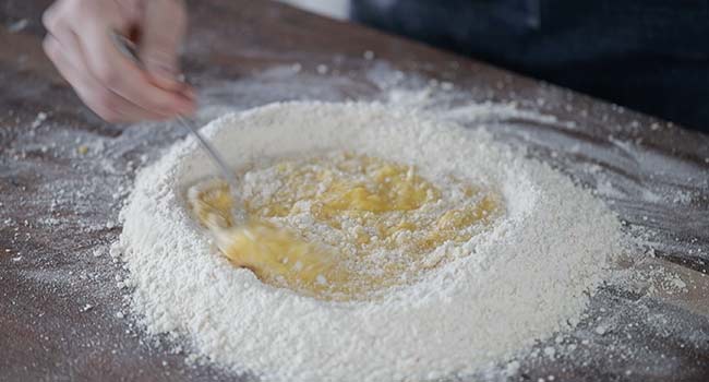 mixing whisked eggs with flour