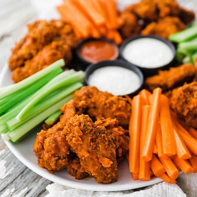 platter of buffalo wings with carrots and celery