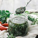 jar of chimichurri sauce with herbs and pepper