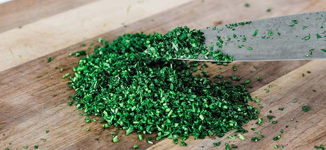 minced parsley on a board with a knife