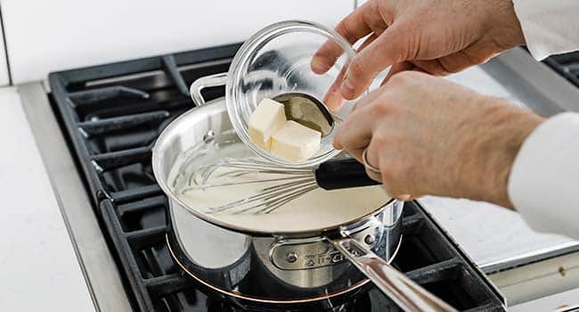 adding butter to the mornay sauce pot