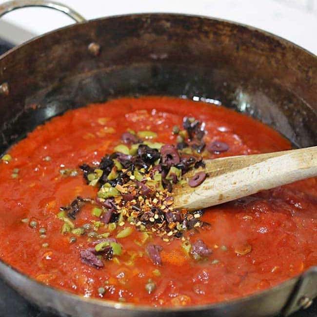 large pot with tomatoes and olives