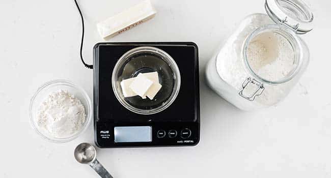 measuring butter and flour on a scale for making a roux recipe