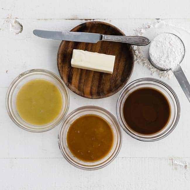 three bowls of different colored roux with butter and flour - ingredients for how to make a roux