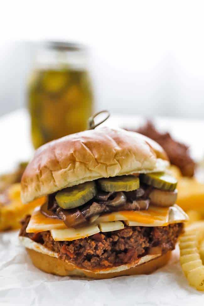 sloppy joe on a brioche bun with pickles and cheese
