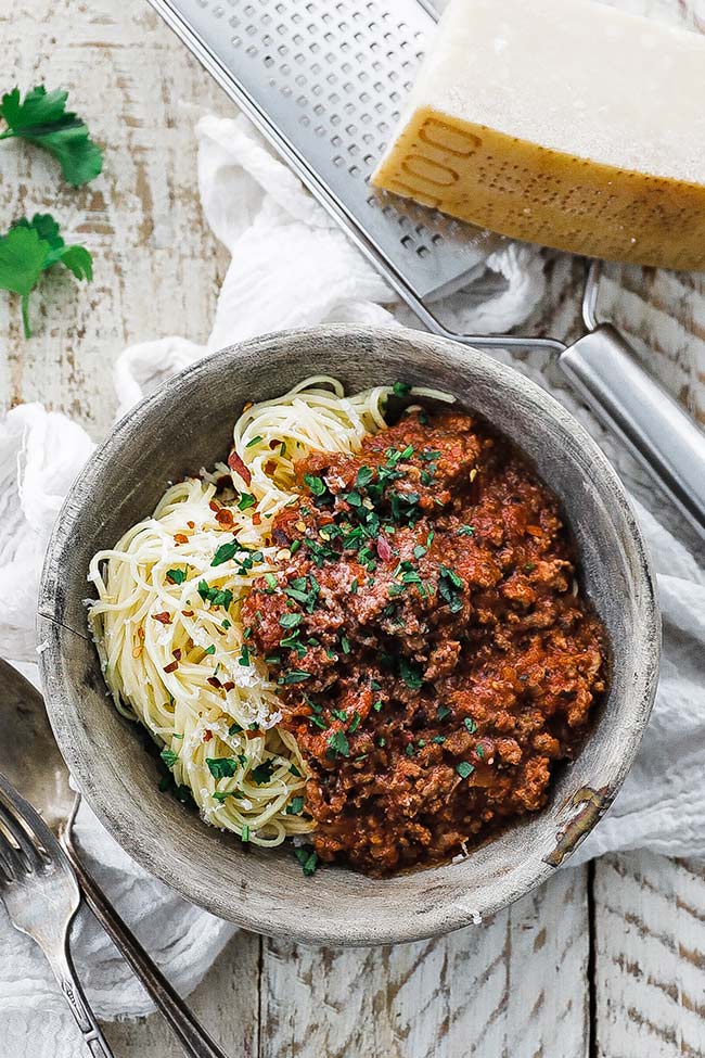 a bowl of fresh spaghetti and sauce with cheese and parsley