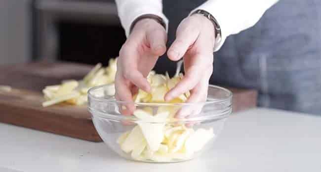 adding apple slices to a bowl