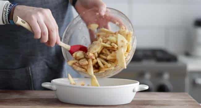 transferring a bowl of apples to a casserole dish