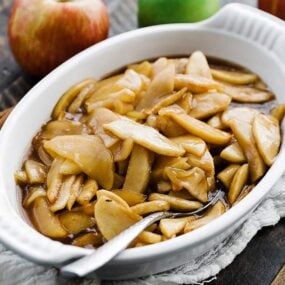 casserole dish of baked apples with a spoon