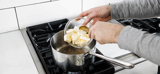 adding cut up butter to a pot