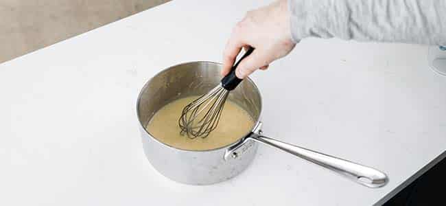whisking the sauce on the countertop