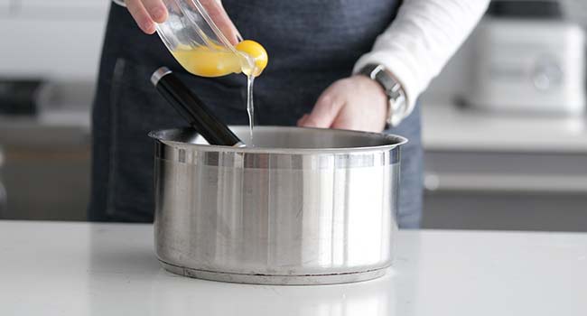 adding eggs to a pot
