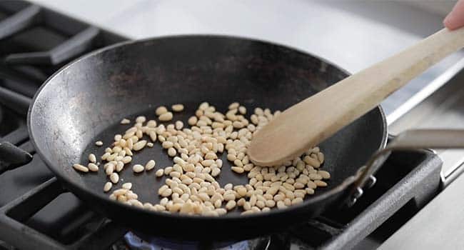 toasting pine nuts in a pan