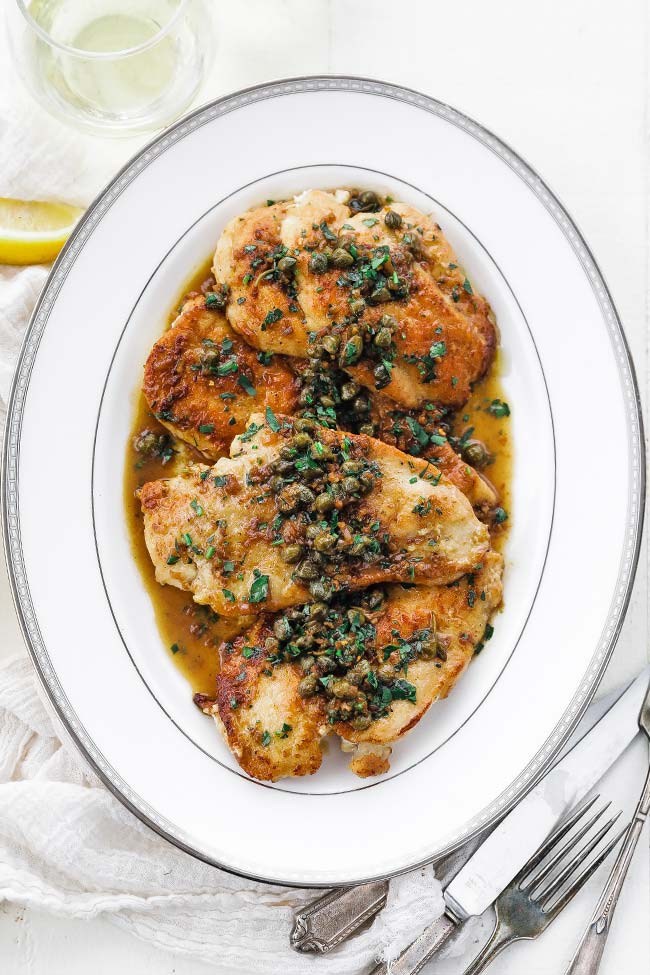 platter of butter sauce and cooked chicken breasts