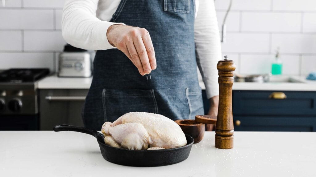 seasoning a chicken with salt