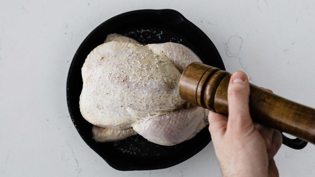 seasoning a chicken with pepper