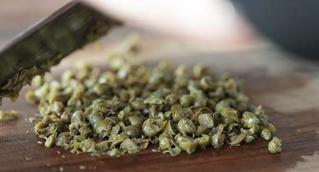 finely chopping capers