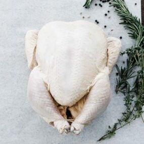 trussed whole chicken on parchment with herbs