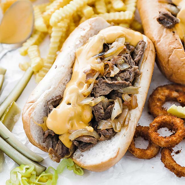 steak sandwich with onions and cheese sauce