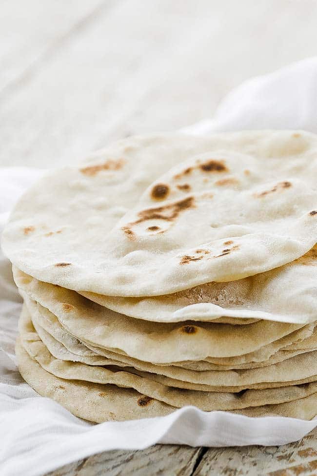 flour tortillas in a stack on cloth