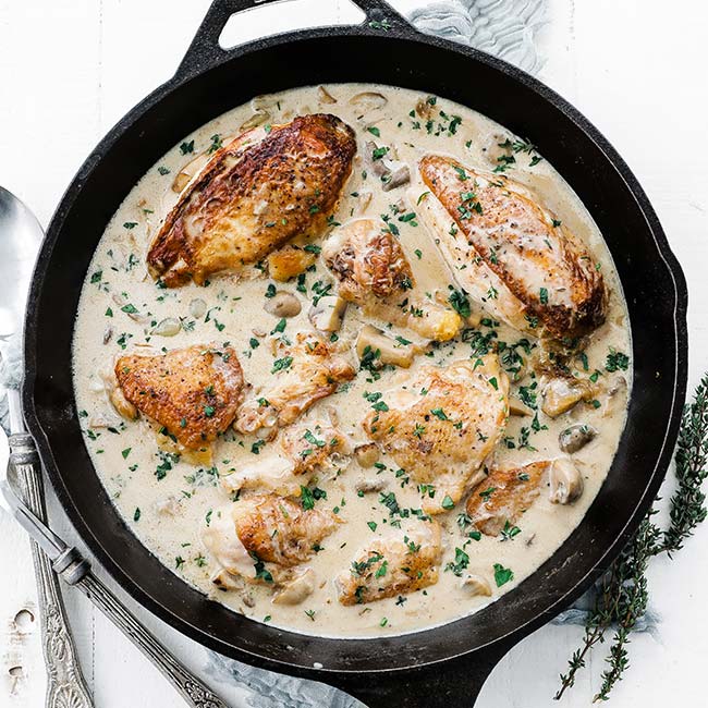 cast-iron pan with roasted chicken and sauce