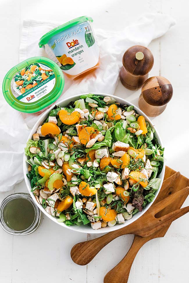 bowl of greens with oranges and nuts