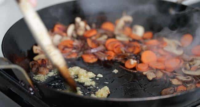 sautéing garlic in a pan with vegetables