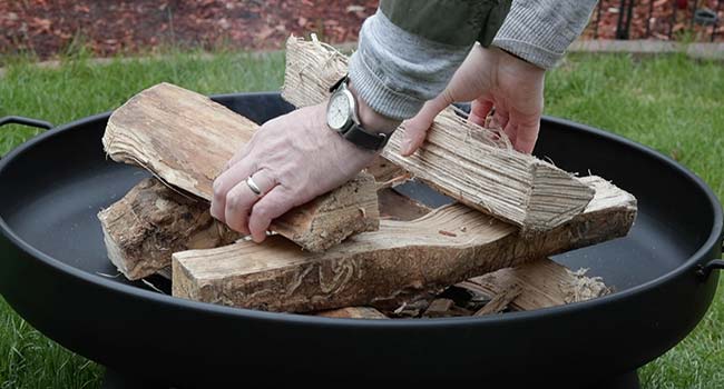 adding two logs to a log stack in a fire pit