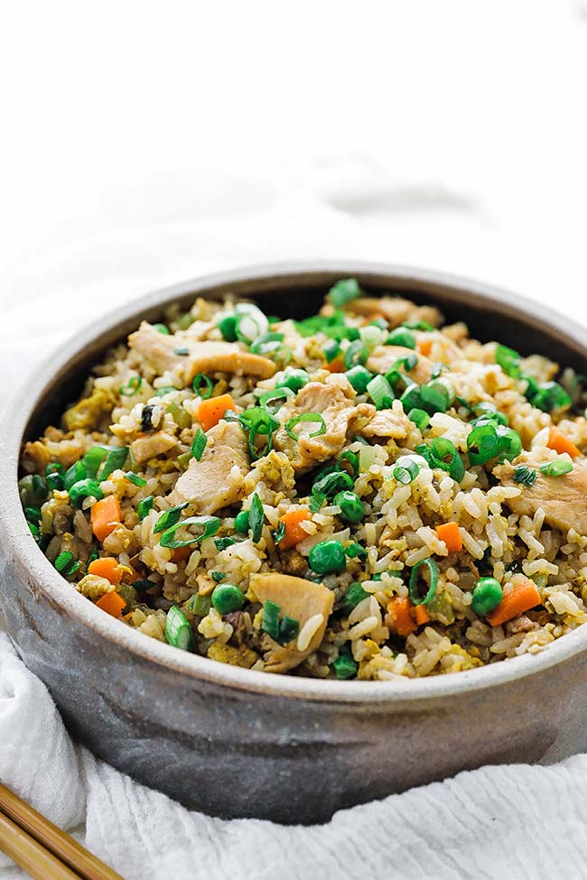 chicken fried rice recipe in a bowl with green onions