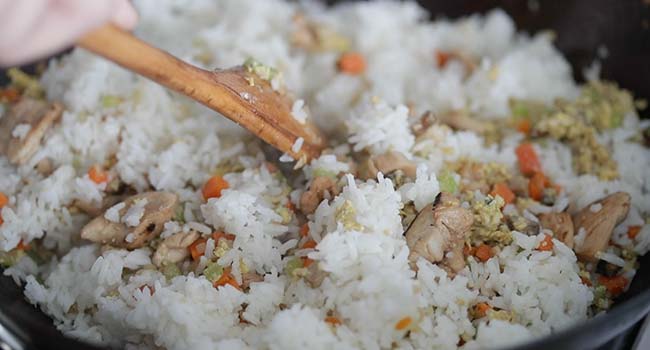 frying rice and chicken with vegetables in a wok