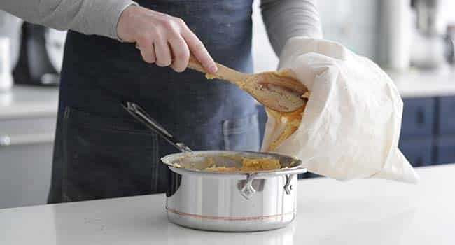 adding dough to a large piping bag