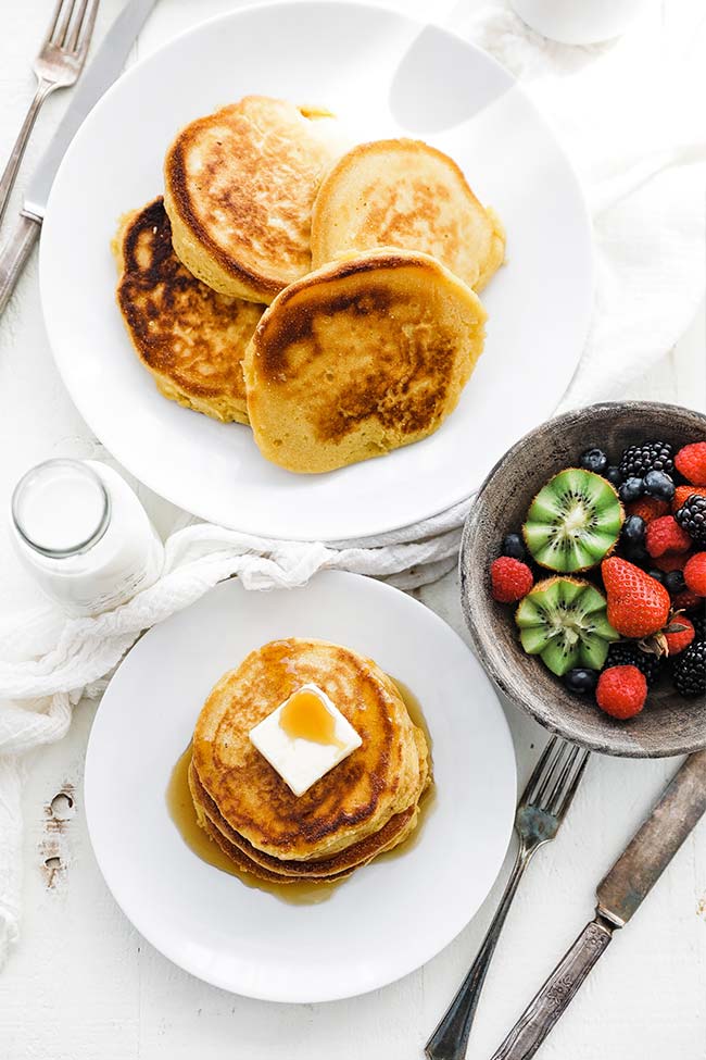 johnny cakes on a plate served with fruit